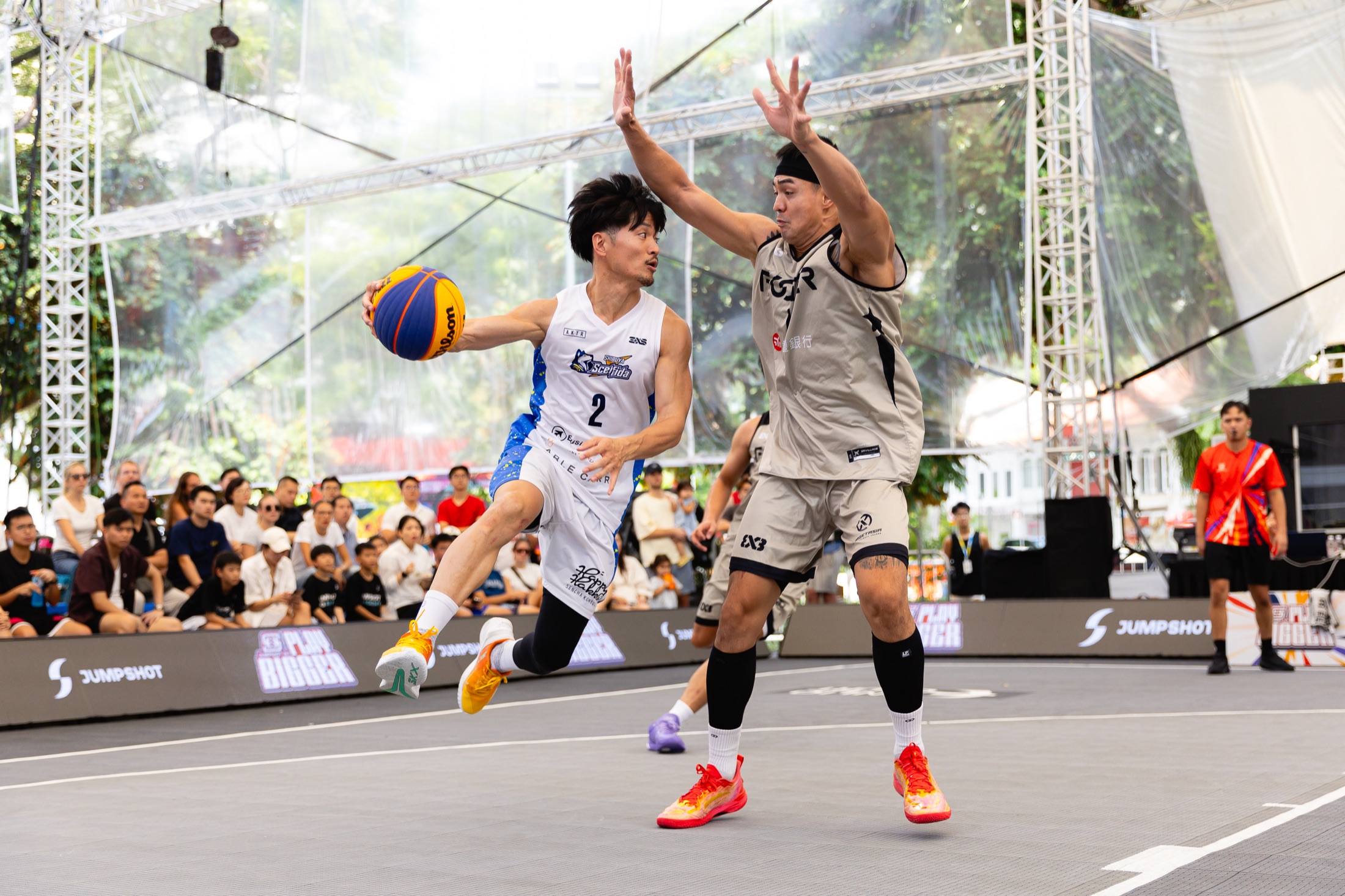 白いユニフォームで跳び、空中でボールを保持するScelfidaの選手
